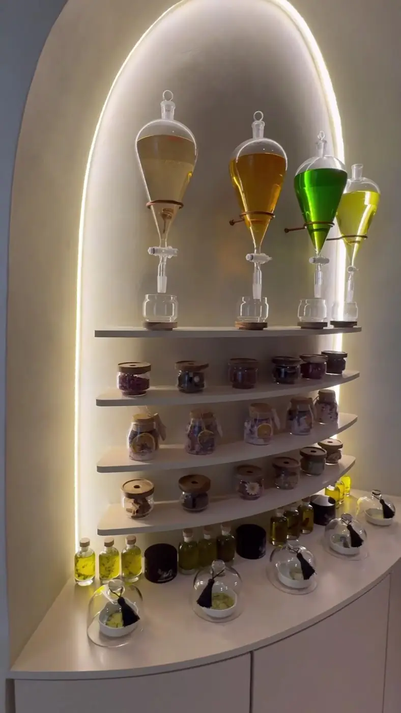 Backlit arch shelf at AVA lined with jars, oils and glass flasks