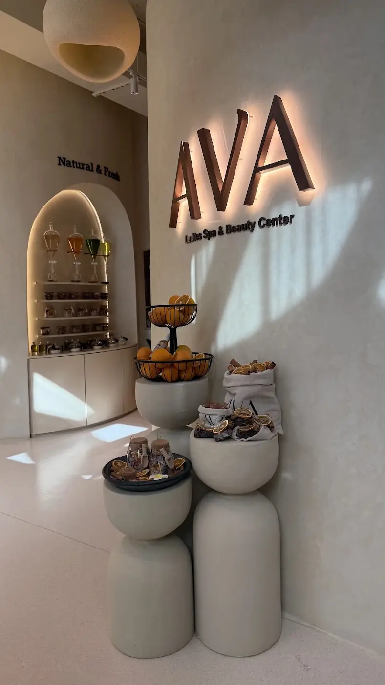AVA Spa Center reception: the lit AVA sign, the Natural & Fresh arch of glass flasks, and bowls of oranges