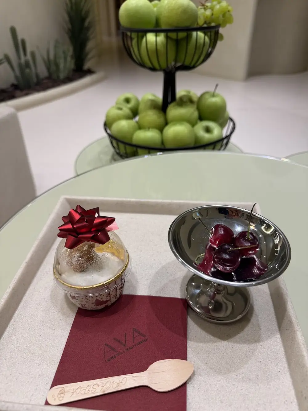 A small gift and a bowl of cherries on an AVA napkin